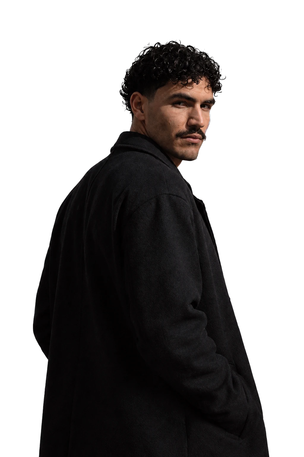 Mathis, fondateur de MTH Studio, en manteau noir, regard par-dessus l'épaule.
